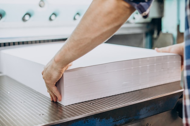 Hombre que trabajaba en la imprenta con papel y pinturas