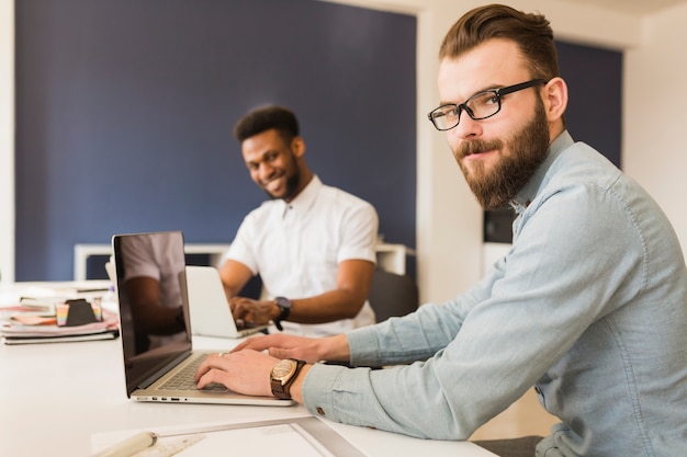 Hombre que usa la computadora portátil en la oficina