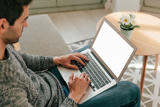 Foto gratuita hombre que usa la computadora portátil en el sofá