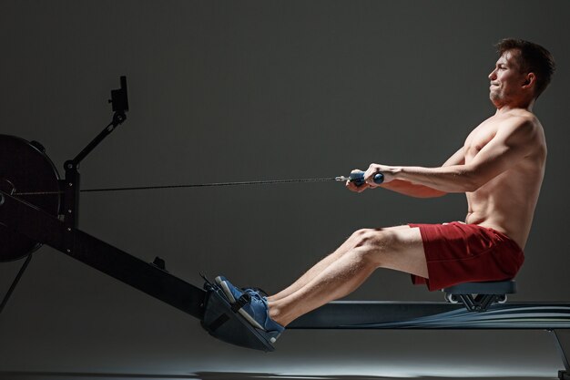 Hombre que usa una máquina de prensa en un gimnasio.