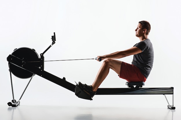 Hombre que usa una máquina de prensa en un gimnasio.