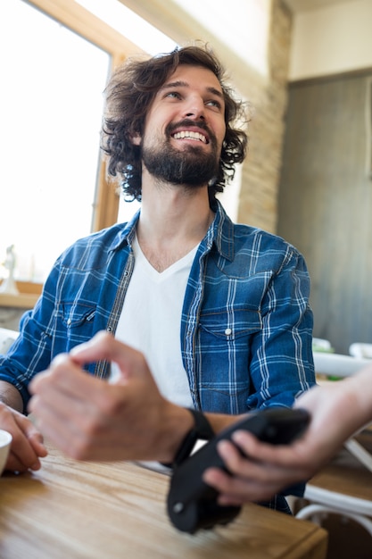 Foto gratuita hombre que usa el reloj inteligente para el pago expreso