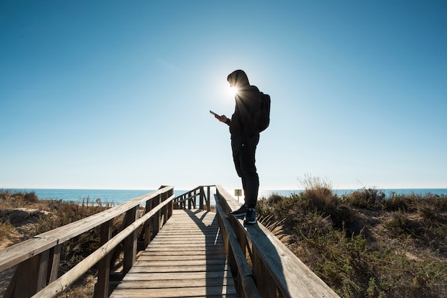 Hombre que usa smartphone en barandillas