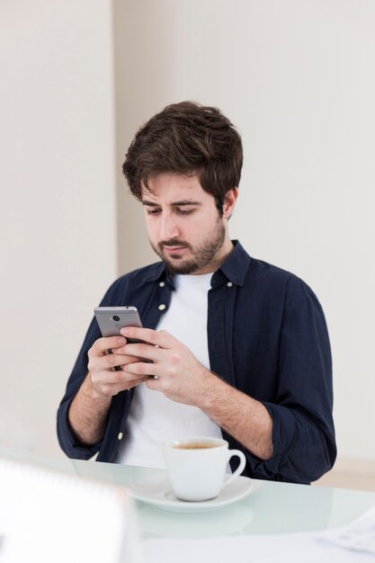 Hombre que usa el teléfono inteligente durante el descanso