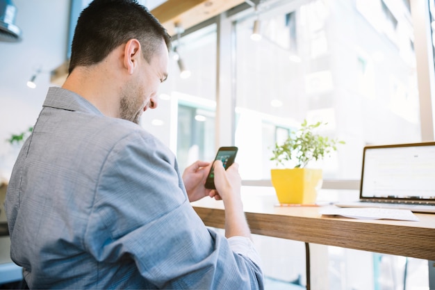 Foto gratuita hombre que usa el teléfono en la oficina