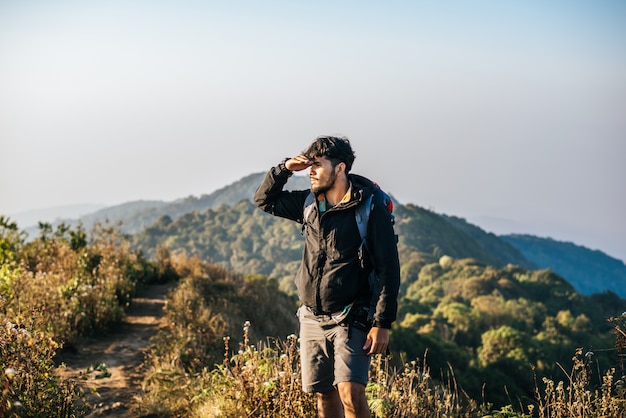 Hombre que viaja con mochila de senderismo en las montañas