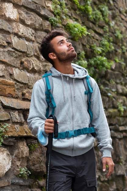 Hombre que viaja solo en mutriku mientras tiene sus elementos esenciales en una mochila