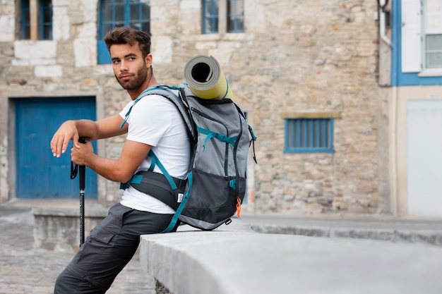 Hombre que viaja solo en mutriku mientras tiene sus elementos esenciales en una mochila