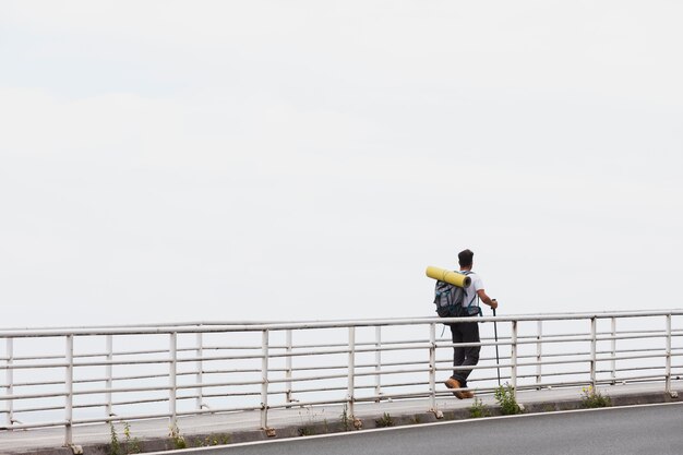 Hombre que viaja solo en mutriku mientras tiene sus elementos esenciales en una mochila