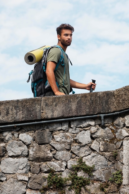 Hombre que viaja solo en mutriku mientras tiene sus elementos esenciales en una mochila