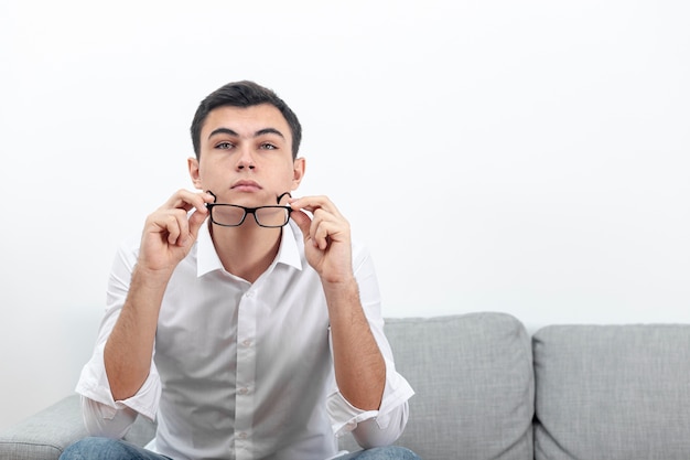 Hombre quitándose las gafas con espacio de copia