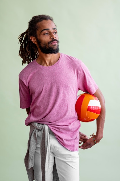 Foto gratuita hombre con rastas jugando baloncesto mientras mira hacia otro lado