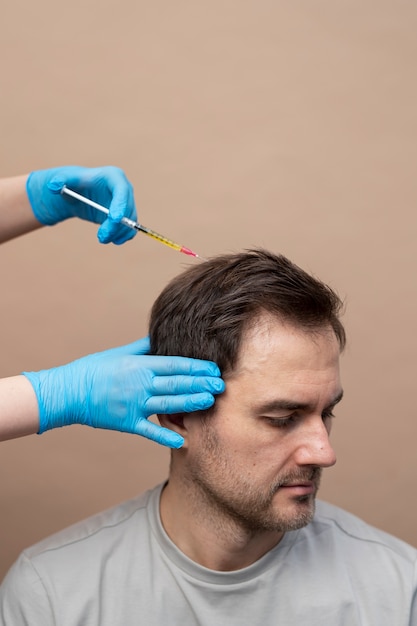 Hombre recibiendo inyección de prp para la alopecia