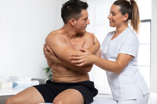 Foto gratuita hombre recibiendo masajes durante la sesión de fisioterapia