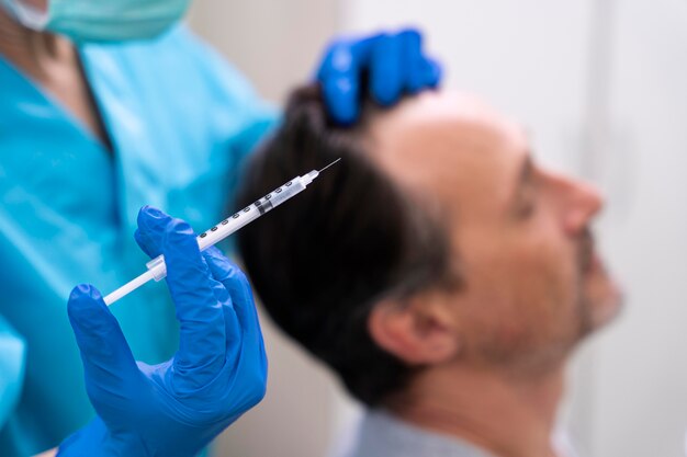 Hombre recibiendo un tratamiento para la caída del cabello