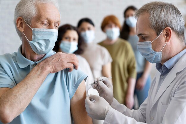 Hombre recibiendo vacuna inyectada por médico con máscara médica