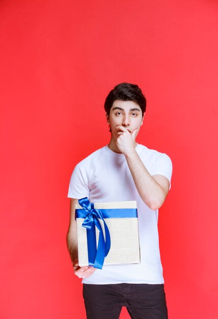 El hombre recibió una caja de regalo blanca y parece sorprendido