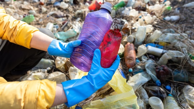 Foto gratuita hombre recogiendo botellas de plástico esparcidas por el suelo