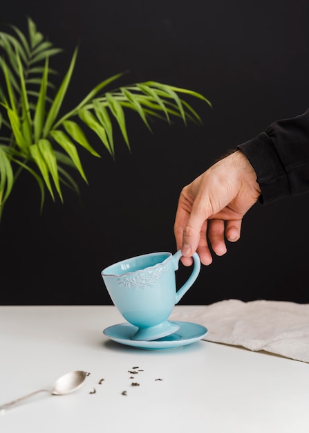 Foto gratuita hombre recogiendo una taza de té