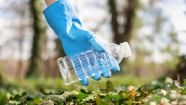 Hombre en la recolección de basura plástica en un parque contaminado