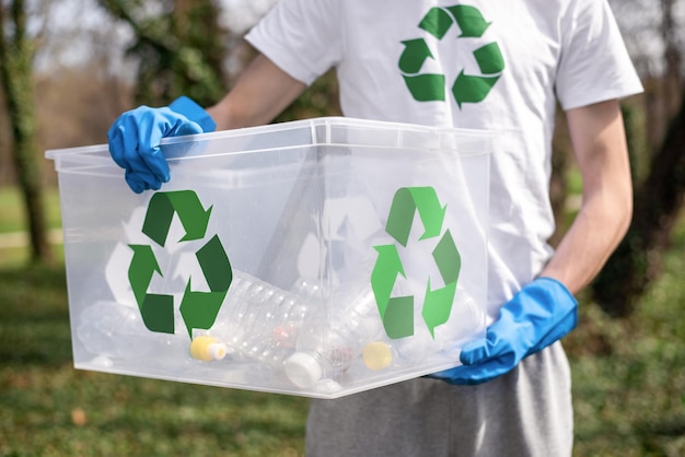 Foto gratuita hombre en la recolección de basura plástica en un parque contaminado