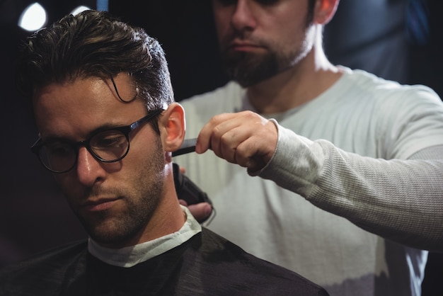 El hombre se recorta el pelo con recortadora