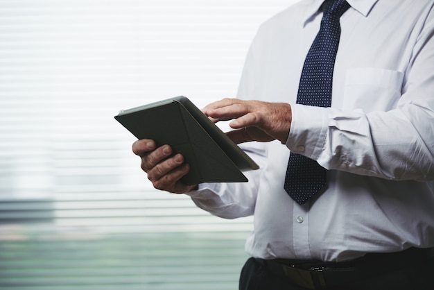 Hombre recortado usando la aplicación de negocios en su dispositivo portátil