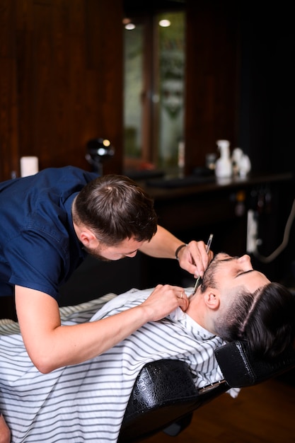 Hombre recortándose la barba en el salón