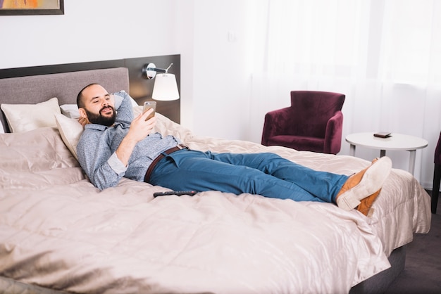 Hombre de refrigeración con teléfono inteligente