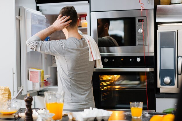 Hombre por refrigerador abierto