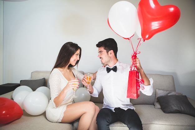 Foto gratuita hombre con regalos tomando una copa con su mujer