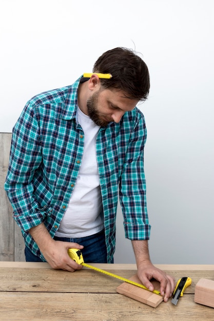 Hombre con regla y concepto de taller de carpintería de madera