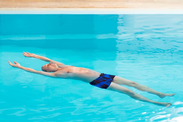 Foto gratuita un hombre relajado en la piscina.