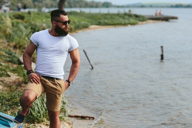 Hombre relajado posando con el lago de fondo