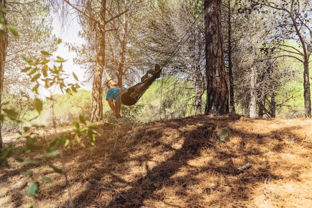 Hombre relajando en hamaca en bosque