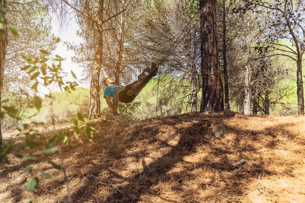 Hombre relajando en hamaca en bosque