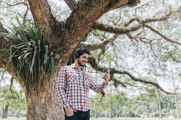 Hombre relajante con teléfono y auriculares