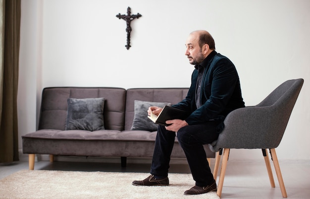 Hombre religioso sosteniendo un libro sagrado en el interior