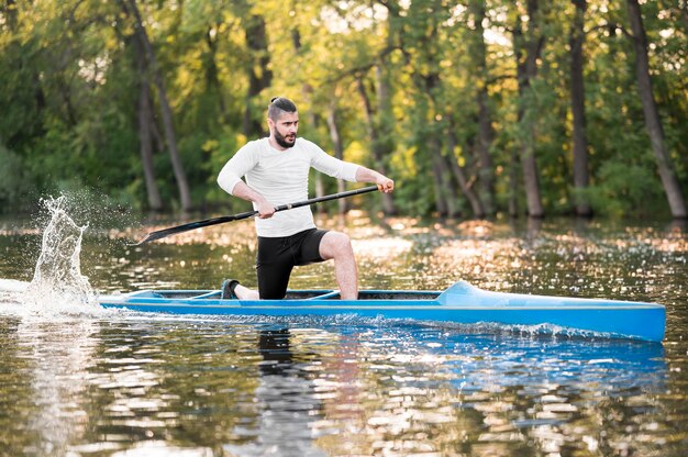 Hombre remando en canoa azul