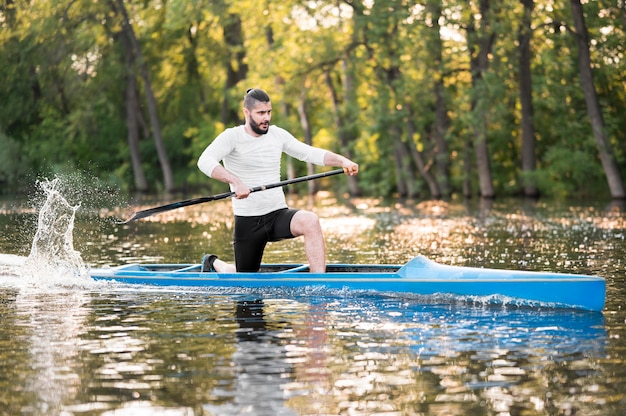 Hombre remando en canoa azul