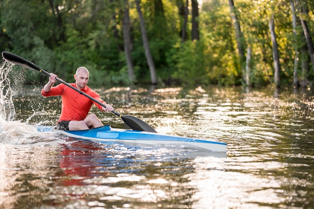 Hombre remando en canoa azul