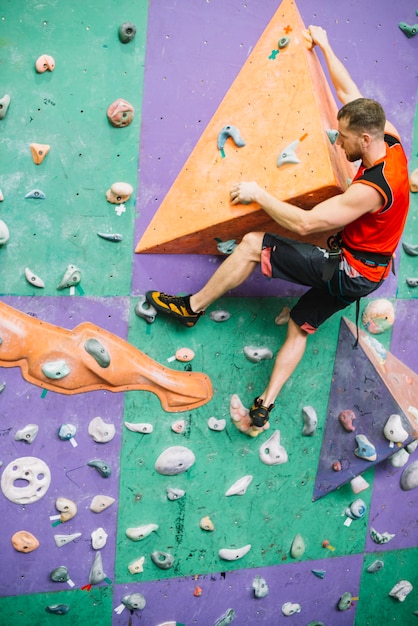 Foto gratuita hombre en la repisa de la pared de escalada