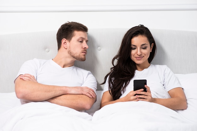Hombre revisando la conversación de su novia en su teléfono