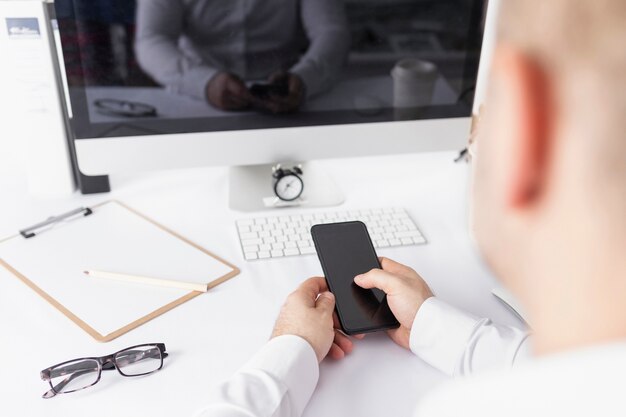 Hombre revisando su teléfono en la oficina