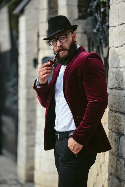 Un hombre rico con barba fuma cigarrillo electrónico.