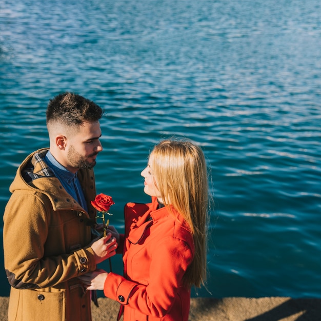 Foto gratuita hombre romántico dando rosa a novia