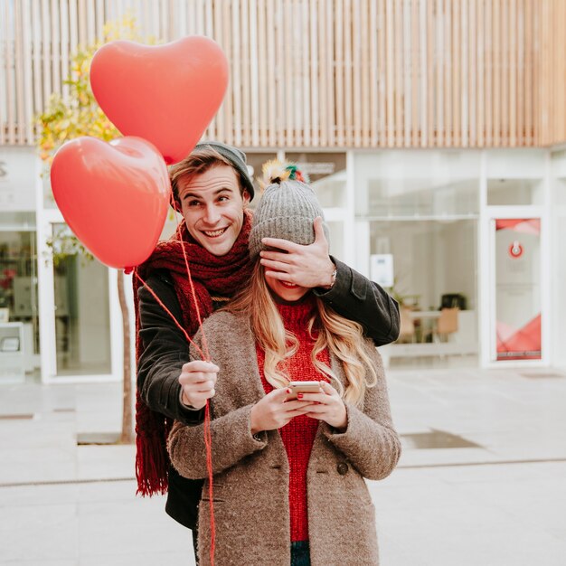 Hombre romántico sorprendente mujer con globos