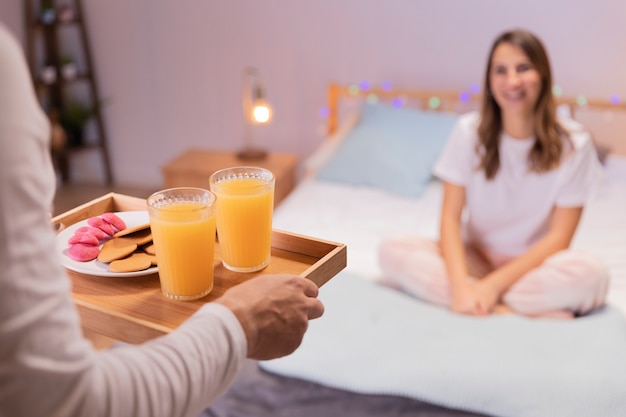 Foto gratuita hombre romántico trae desayuno a su esposa