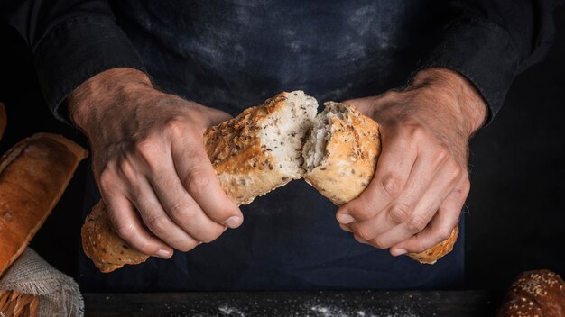 Hombre rompiendo una hogaza de pan