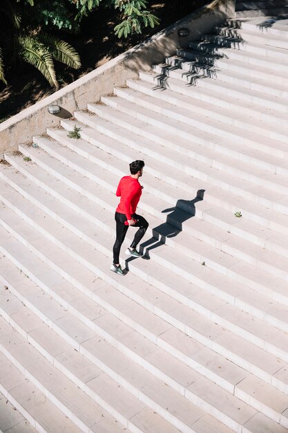 Hombre en ropa deportiva corriendo arriba